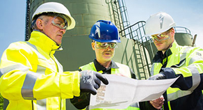 Drei Arbeiter mit Schutzhelm und Schutzbrille